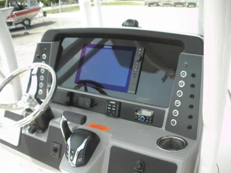 Slide: The Image of 2026 Robalo R230 Center Console dashboard with steering wheel and electronic controls. - 11