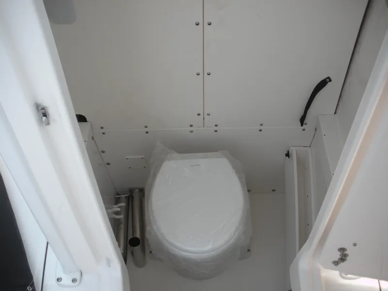 Slide: The Image of 2026 Robalo R230 Center Console boat interior with a compact marine toilet. - 12