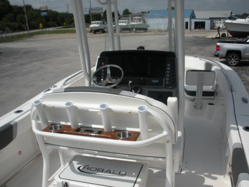 Slide: The Image of 2026 Robalo R230 Center Console boat interior with steering wheel and rod holders. - 17