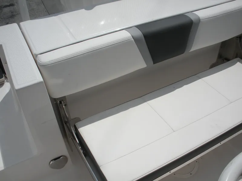 Slide: The Image of 2026 Robalo R230 Center Console boat seat, white and gray upholstery, open storage compartment. - 20