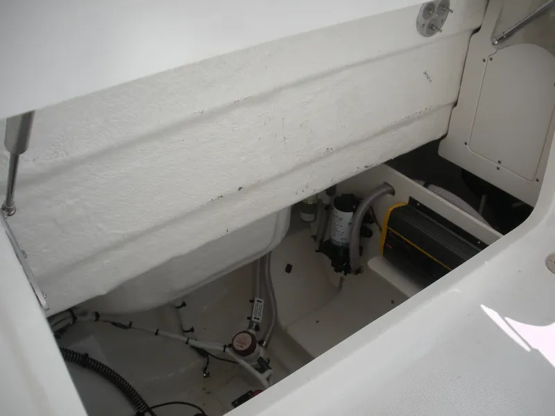 Slide: The Image of 2026 Robalo R230 Center Console boat interior compartment with visible wiring and equipment. - 22