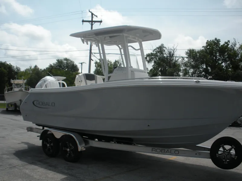 Slide: The Image of 2026 Robalo R230 Center Console boat on trailer, parked outdoors. - 4