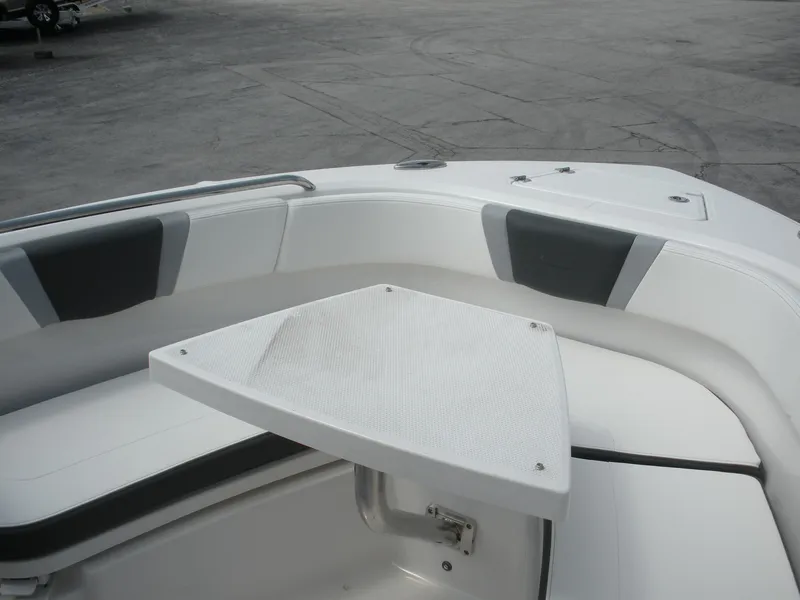 Slide: The Image of 2026 Robalo R230 Center Console boat interior with seating and table. - 7