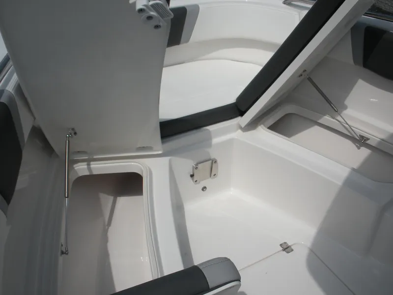 Slide: The Image of 2026 Robalo R230 Center Console boat storage compartments open, showcasing spacious interior design. - 8