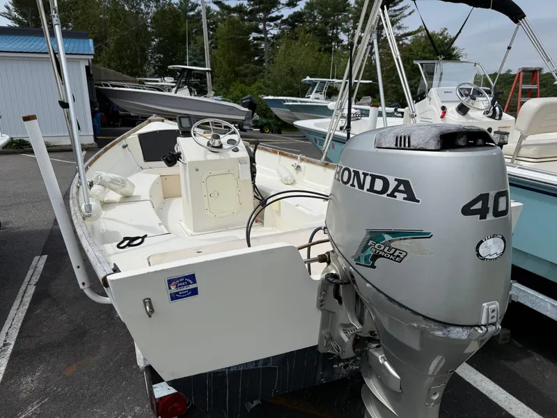 Slide: The Image of 2001 Bristol Skiff 17 with Honda 40 outboard motor, parked in a marina. - 2