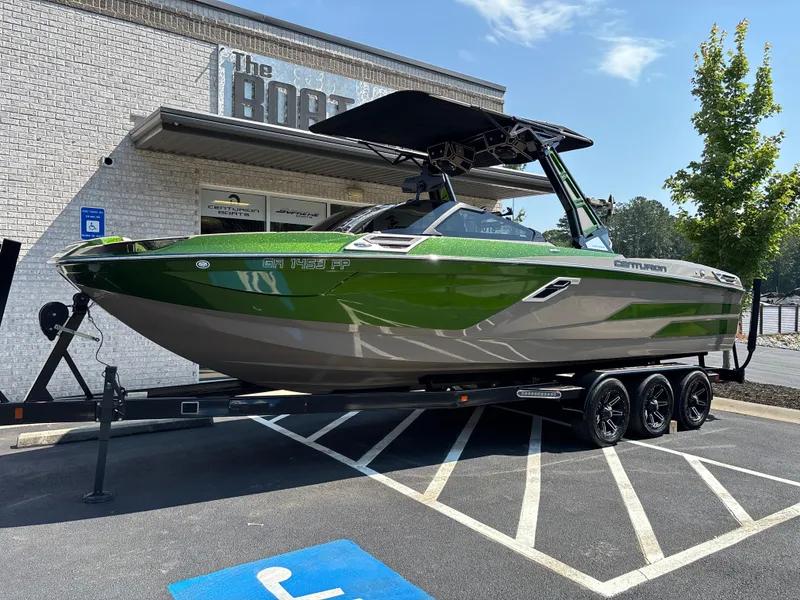The Image of 2023 Centurion Ri265 boat in green and gray on a trailer outside a dealership. - 1