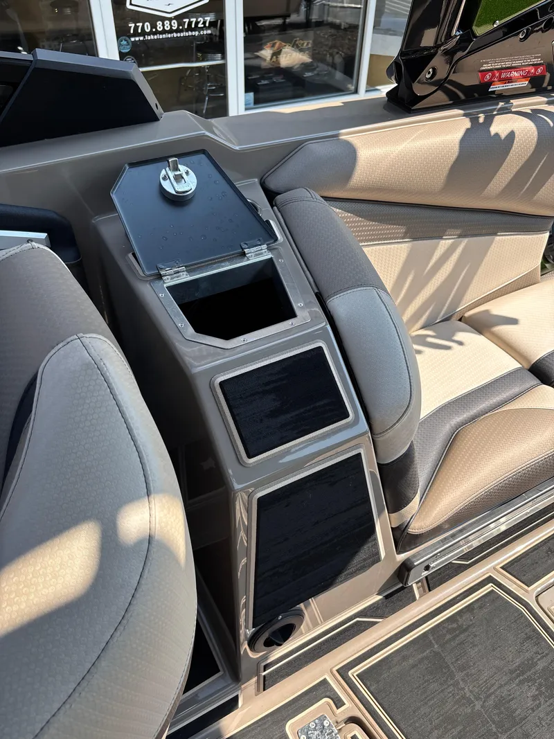Slide: The Image of 2023 Centurion Ri265 boat interior with beige seating and storage compartments. - 12