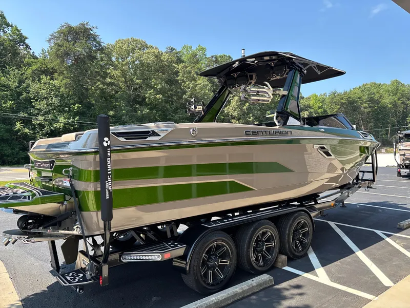 Slide: The Image of 2023 Centurion Ri265 boat on trailer, green and beige design, parked outdoors. - 4