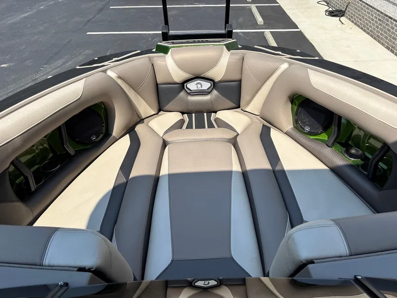 Slide: The Image of 2023 Centurion Ri265 boat interior with beige and gray seating in a parking lot. - 6