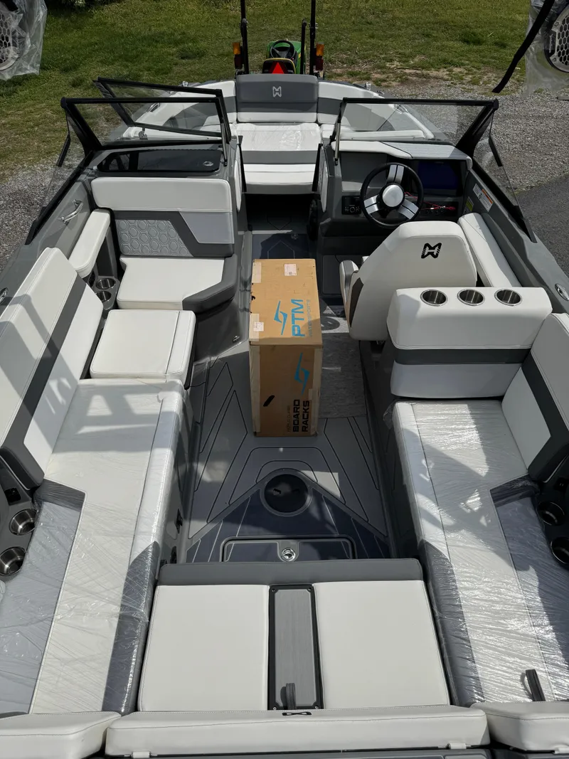 Slide: The Image of 2025 Heyday H22 boat interior with modern seating and steering wheel, featuring a central cardboard box. - 6
