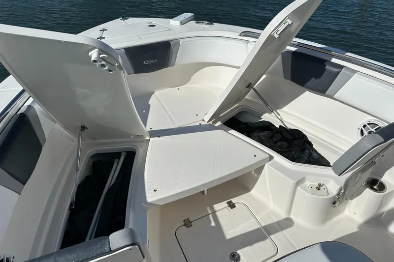 Slide: The Image of 2021 Robalo R230 Center Console boat with open storage compartments on deck. - 10