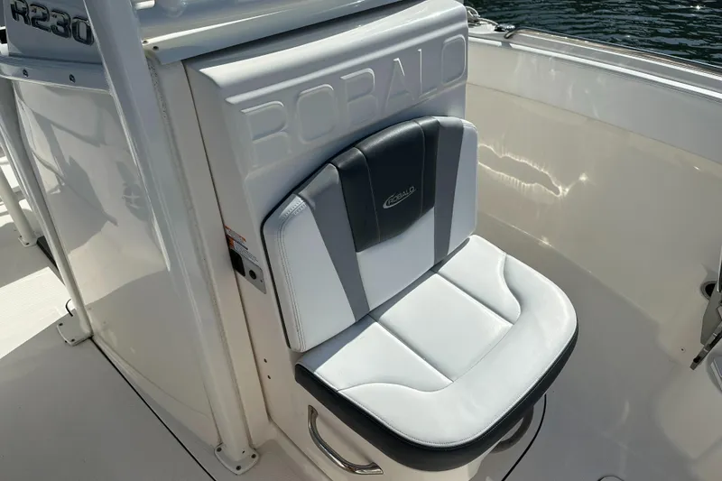 Slide: The Image of 2021 Robalo R230 Center Console boat seat, white and black design, on deck. - 12