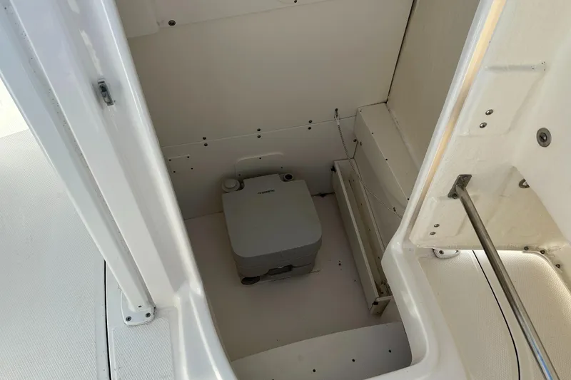 Slide: The Image of 2021 Robalo R230 Center Console boat interior with compact marine toilet. - 14