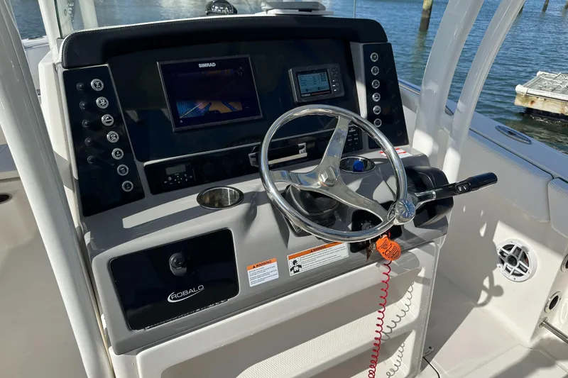 Slide: The Image of 2021 Robalo R230 Center Console boat dashboard with steering wheel and navigation system. - 22