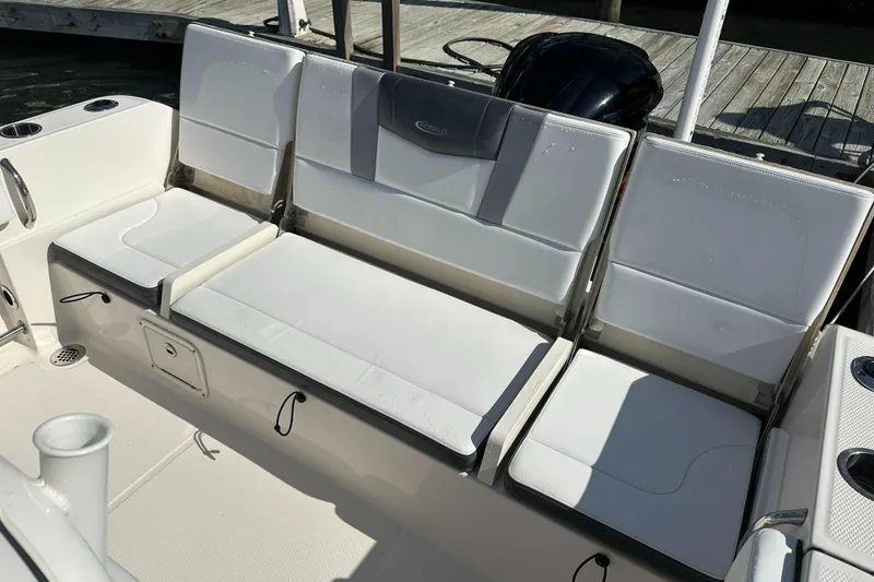 Slide: The Image of 2021 Robalo R230 Center Console boat seating area with white cushioned seats. - 25