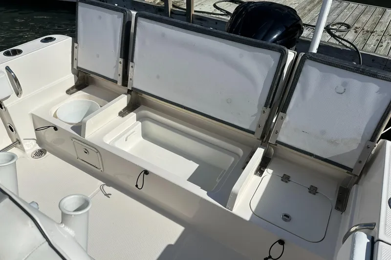 Slide: The Image of 2021 Robalo R230 Center Console boat with open storage compartments and cup holders. - 26