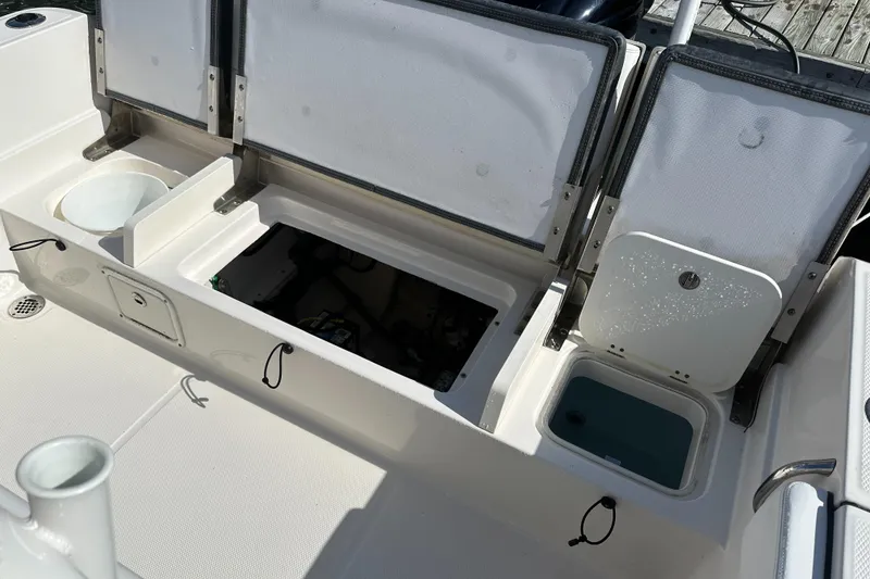 Slide: The Image of 2021 Robalo R230 Center Console boat storage compartments and seating area. - 27