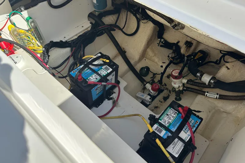 Slide: The Image of 2021 Robalo R230 Center Console boat battery compartment with wiring and components. - 28