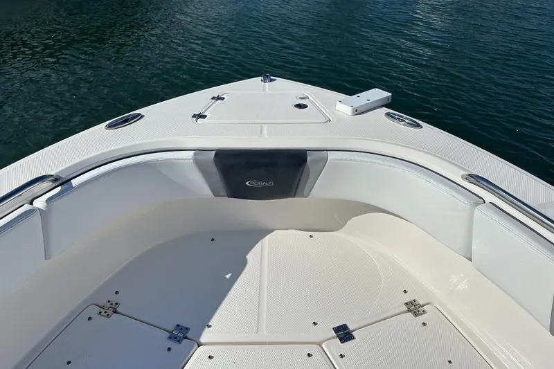 Slide: The Image of 2021 Robalo R230 Center Console boat bow with seating, on calm water. - 7