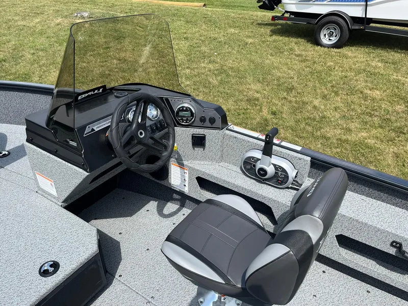Slide: The Image of 2026 Lund 1775 Adventure SS boat interior with steering console and seat on grass. - 14