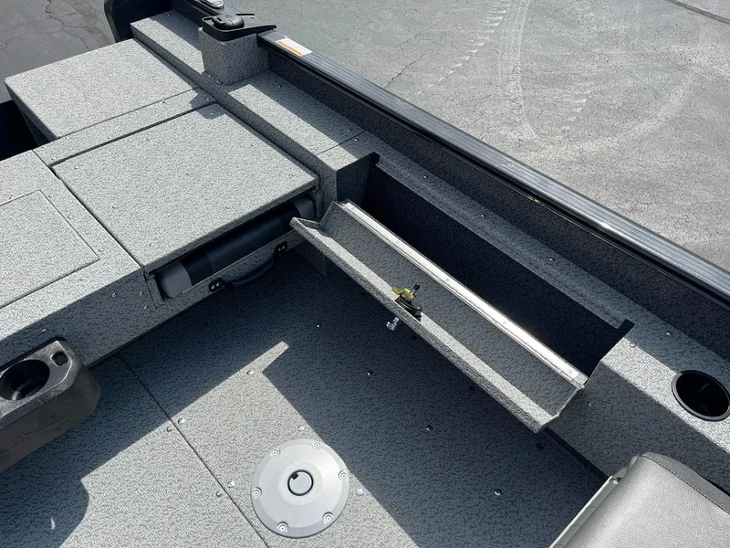 Slide: The Image of 2026 Lund 1775 Adventure SS boat interior with storage compartments and cup holder. - 19