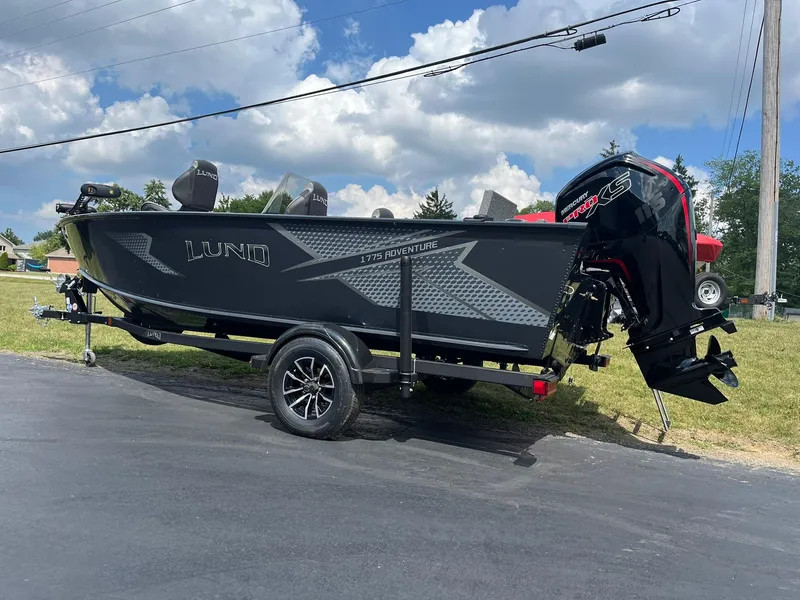 Slide: The Image of 2026 Lund 1775 Adventure SS boat on trailer under a partly cloudy sky. - 3