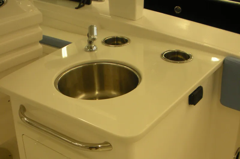 Slide: The Image of 2026 Robalo R257 Dual Console boat sink with faucet and cup holders. - 12