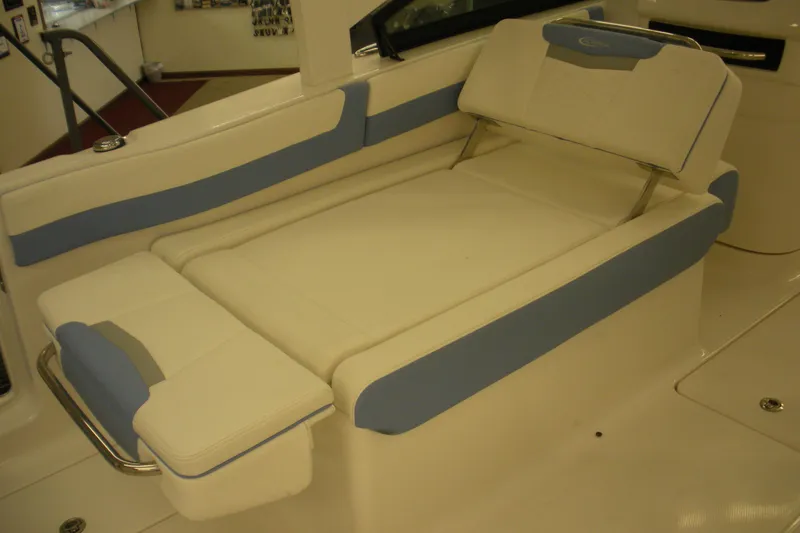 Slide: The Image of 2026 Robalo R257 Dual Console boat interior with cushioned seating in white and blue. - 13
