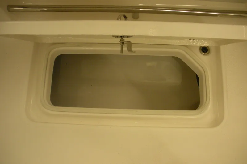 Slide: The Image of 2026 Robalo R257 Dual Console storage compartment, featuring a sleek, white interior design. - 14