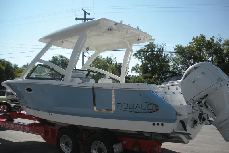 Slide: The Image of 2026 Robalo R257 Dual Console boat on trailer, featuring sleek design and powerful engine. - 19
