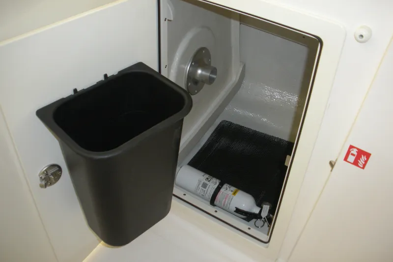 Slide: The Image of Storage compartment with fire extinguisher in 2026 Robalo R257 Dual Console boat. - 4