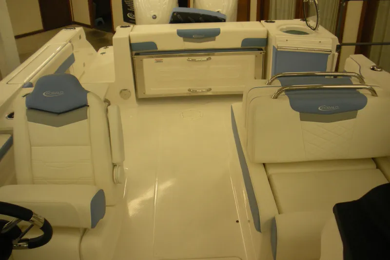 Slide: The Image of 2026 Robalo R257 Dual Console interior with white and blue seating, modern design. - 7