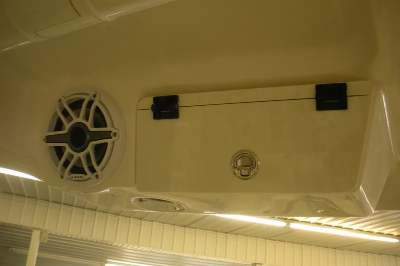 Slide: The Image of 2026 Robalo R257 Dual Console boat interior with speaker and storage compartment. - 8