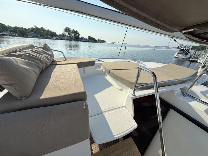 Slide: The Image of Luxurious 2015 Fountaine Pajot Helia 44 catamaran with sunbathing area, docked by serene waters. - 10