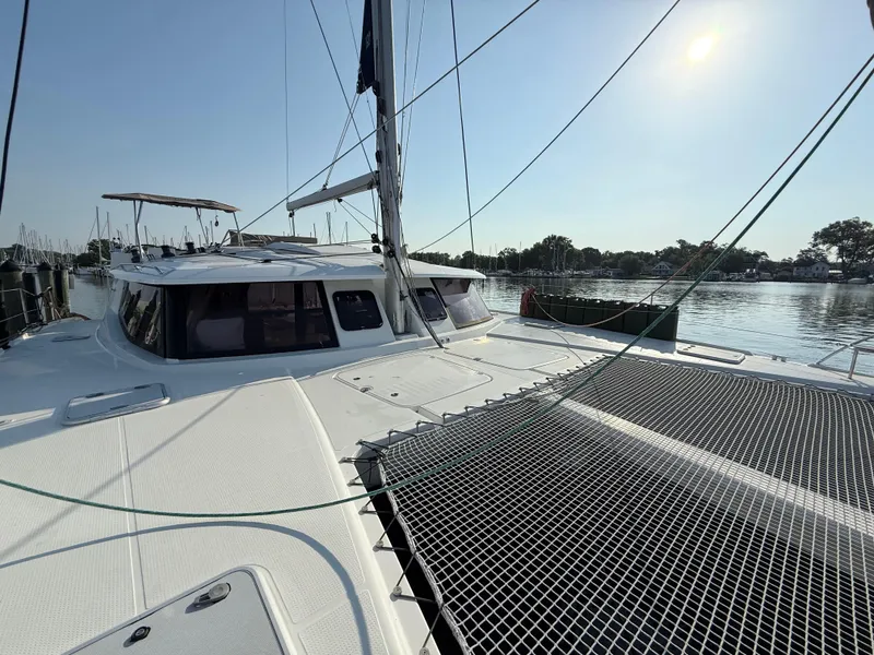Slide: The Image of 2015 Fountaine Pajot Helia 44 catamaran docked in a serene marina setting. - 14