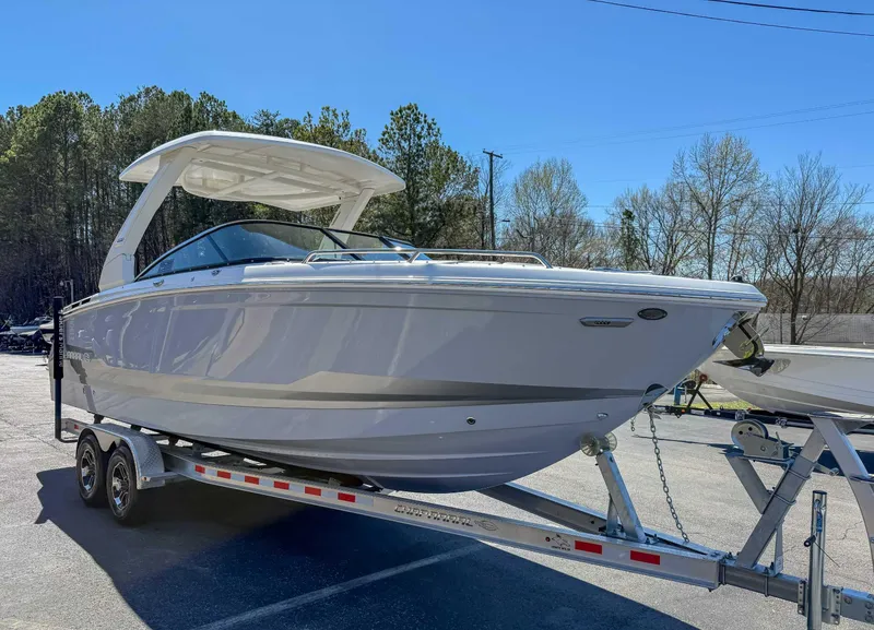 Slide: The Image of 2025 Chaparral 2870 SSX boat on trailer, parked outdoors under clear blue sky. - 5