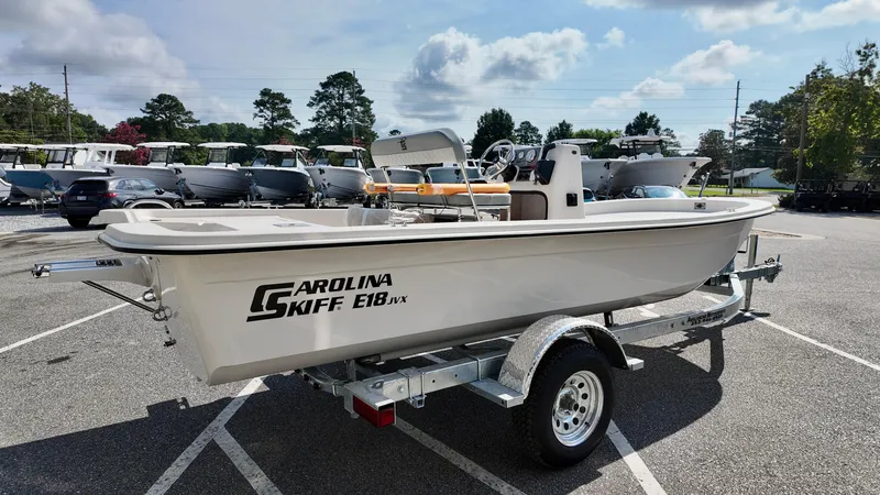 Slide: The Image of 2025 Carolina Skiff E18 JVX CC boat on trailer in parking lot. - 10