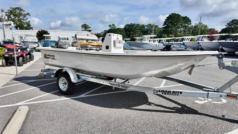 Slide: The Image of 2025 Carolina Skiff E18 JVX CC boat on a trailer in a parking lot. - 11