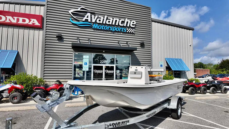 Slide: The Image of 2025 Carolina Skiff E18 JVX CC boat on trailer at Avalanche Motorsports dealership. - 13