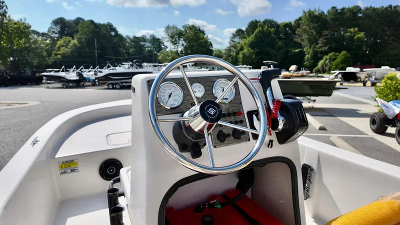 Slide: The Image of 2025 Carolina Skiff E18 JVX CC boat dashboard with steering wheel and controls. - 3