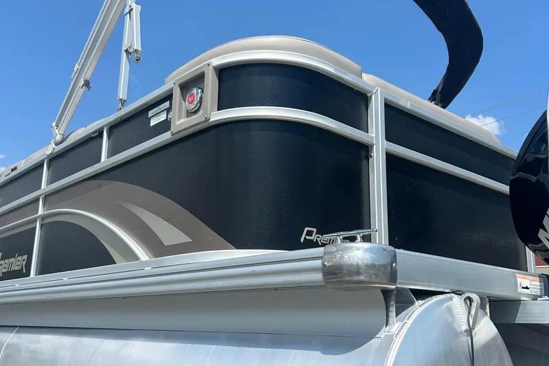 Slide: The Image of 2014 Premier 220 SunSation pontoon boat, black and silver exterior, under clear blue sky. - 10