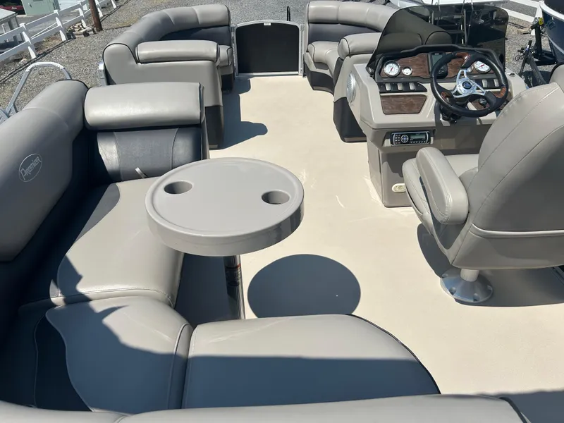 Slide: The Image of 2014 Premier 220 SunSation pontoon boat interior with plush seating and steering console. - 12