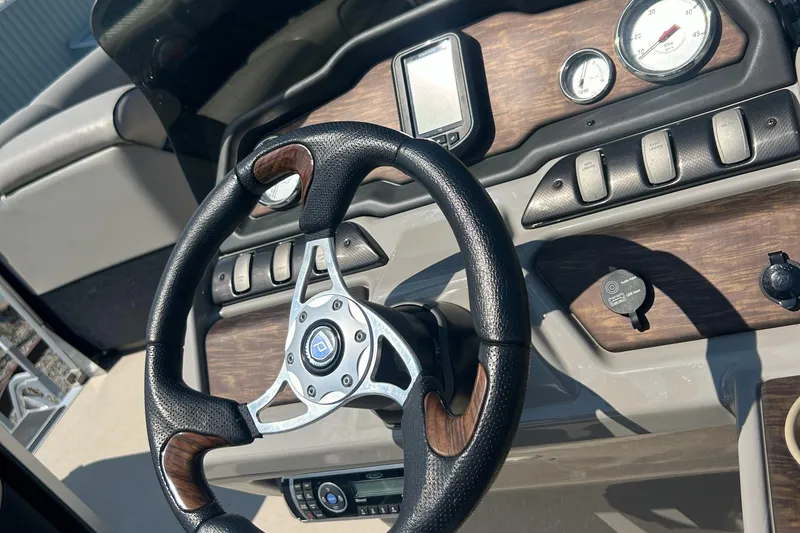 Slide: The Image of Steering wheel and dashboard of 2014 Premier 220 SunSation boat with wood accents. - 13