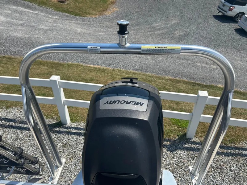 Slide: The Image of 2014 Premier 220 SunSation boat with Mercury engine, parked on gravel near white fence. - 18