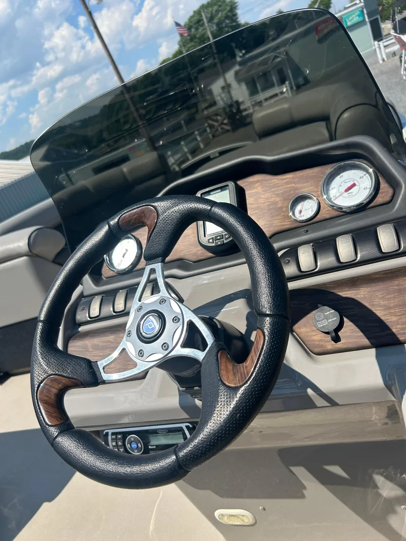 Slide: The Image of Steering wheel and dashboard of 2014 Premier 220 SunSation boat, featuring gauges and controls. - 19