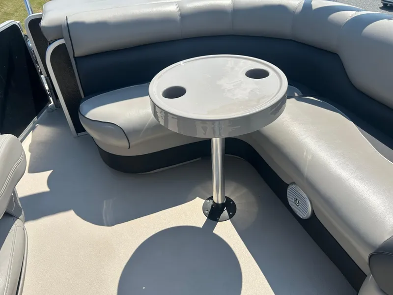 Slide: The Image of 2014 Premier 220 SunSation boat interior with round table and cushioned seating. - 21