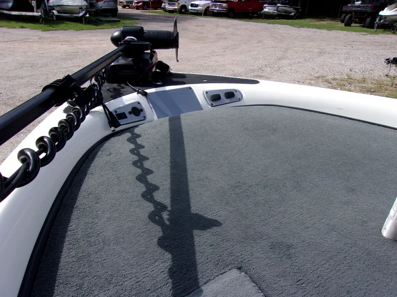 Slide: The Image of 2004 Stratos 275 Pro XL boat deck with trolling motor in a parking lot. - 10