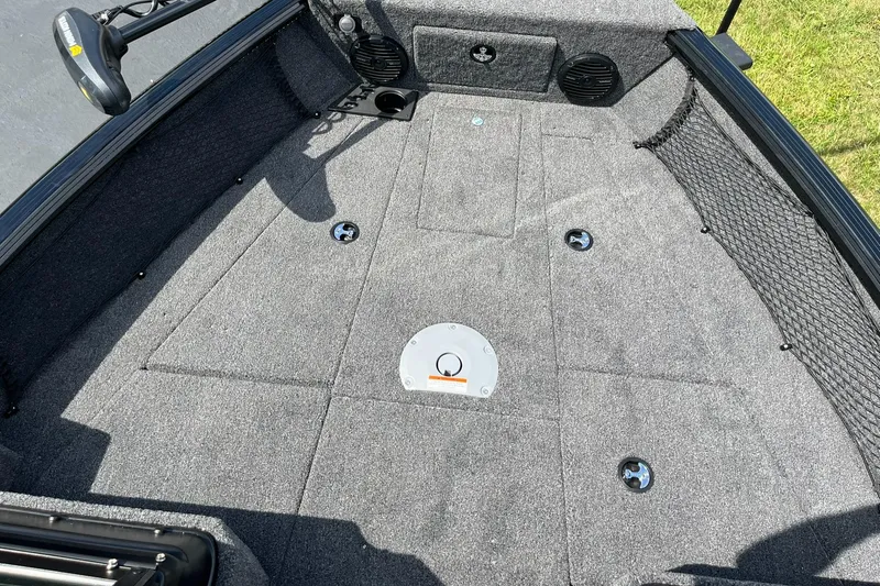 Slide: The Image of 2026 Lund 1775 Impact XS Sport boat deck with carpeted surface and storage compartments. - 10