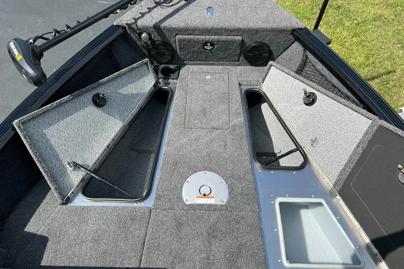 Slide: The Image of 2026 Lund 1775 Impact XS Sport boat interior with open storage compartments and fishing gear. - 11