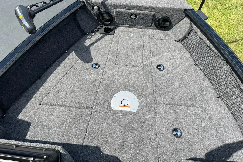 Slide: The Image of 2026 Lund 1775 Impact XS Sport boat interior with carpeted deck and storage compartments. - 12